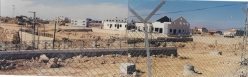 שורת הבתים ברחוב הל"ה (דון, מילנר, פרל, מילסטון) ומבנה הגנרטור הצמוד לאמפיתאטרון, במבט מכיוון צפון מזרח. הבתים ברחוב מגיני הגוש נראים בתמונה כהתחלות בניה